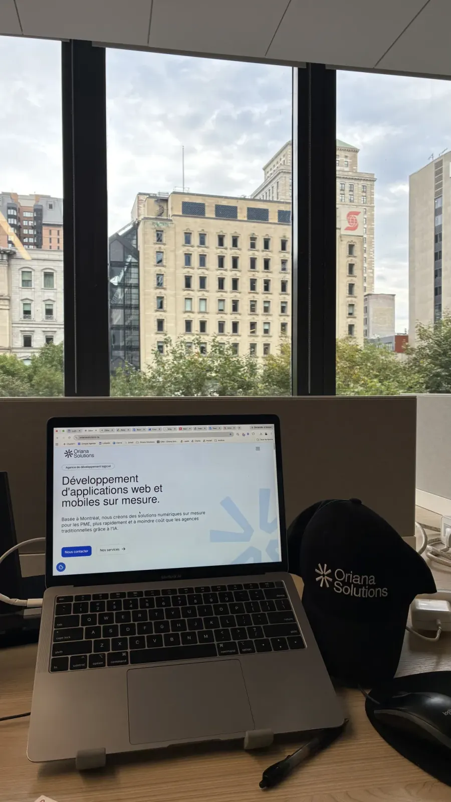 Poste de travail d'Oriana Solutions chez Ax.c, avec vue sur les édifices du centre-ville de Montréal